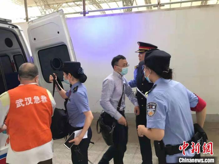 姚文龙(中间戴眼镜男士)与乘警一同将晕倒乘客送上救护车才离去。　郑州铁路公安处供图 摄