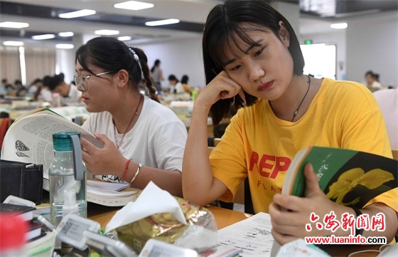 7月16日,皖西学院的大三学生在阅览室里阅读考研复习资料.