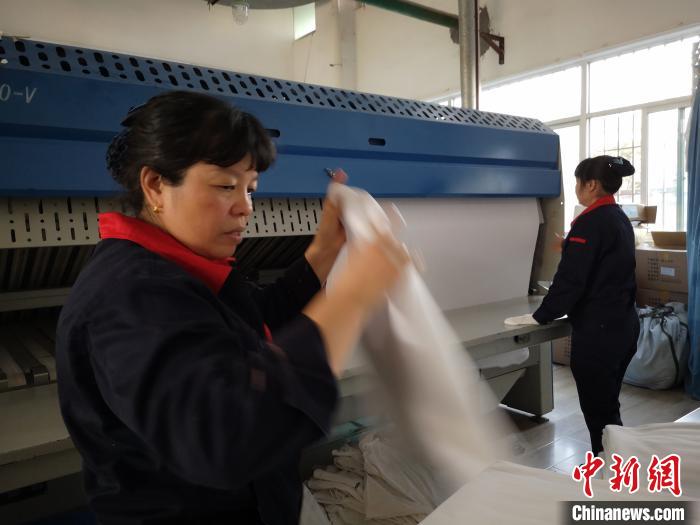 工人收取高温消毒后的卧具。 雍万俊 摄