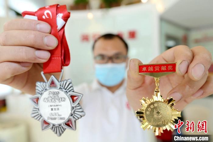 夏龙须展示他的献血荣誉奖牌 王亚东 摄